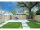 Fenced backyard featuring a concrete patio, lush grass, stepping stones and shade from mature trees at 1425 Kennington St, Indianapolis, IN 46225
