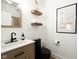 Modern bathroom features a wood vanity, black fixtures, and floating wood shelves at 1425 Kennington St, Indianapolis, IN 46225