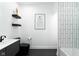 Elegant bathroom features dark vanity, floating shelves, and black matte fixtures at 1425 Kennington St, Indianapolis, IN 46225