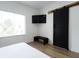 Bright bedroom features a large window, modern sliding door, and simple bench at 1425 Kennington St, Indianapolis, IN 46225