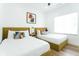 Sunlit bedroom with hardwood floors, two twin beds, and a modern art print at 1425 Kennington St, Indianapolis, IN 46225