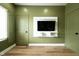 An earthy green bedroom with a modern entertainment center and hardwood floors at 1425 Kennington St, Indianapolis, IN 46225