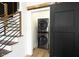 Modern laundry room with wood stairs and a black sliding barn door at 1425 Kennington St, Indianapolis, IN 46225