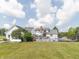 Lush backyard with a swimming pool, a black fence, mature trees, and partial view of a white home at 1595 N 400 W, Greenfield, IN 46140