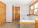 Bright bathroom showcasing a large soaking tub with tile surround and natural wood trim around the window at 1595 N 400 W, Greenfield, IN 46140