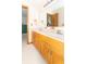 Bright bathroom featuring a double vanity with a large mirror, fixtures, and wood cabinets at 1595 N 400 W, Greenfield, IN 46140