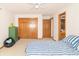 Bright bedroom featuring wood doors, a striped comforter, a green dresser, and an open bathroom at 1595 N 400 W, Greenfield, IN 46140