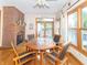 Inviting dining area with hardwood floors, a brick fireplace, and access to the outdoor deck, pool and hot tub at 1595 N 400 W, Greenfield, IN 46140