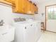 Bright laundry room featuring a white washer and dryer, sink, cabinets, and a door to the outside at 1595 N 400 W, Greenfield, IN 46140