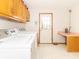 The laundry room features a white washer and dryer, cabinets, a door, and a pink counter at 1595 N 400 W, Greenfield, IN 46140