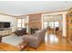 Spacious living room with hardwood floors, a brick fireplace, and views into the adjacent dining room at 1595 N 400 W, Greenfield, IN 46140