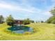 Scenic pond with a fountain, reflecting trees and a covered bridge, showcasing a tranquil setting at 1595 N 400 W, Greenfield, IN 46140