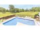 A fenced in ground pool surrounded by green trees and grass under a blue sky at 1595 N 400 W, Greenfield, IN 46140