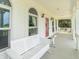 A covered porch with white benches and railings, offering a relaxing outdoor space at 1595 N 400 W, Greenfield, IN 46140