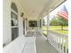 A covered porch with white benches and railings, offering a relaxing outdoor space at 1595 N 400 W, Greenfield, IN 46140