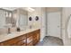 Bathroom boasts double sinks with wood cabinets, neutral walls and tile, a large mirror, and a walk-in shower at 1631 Caspian Dr, Carmel, IN 46032