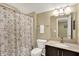 Well-lit bathroom features a toilet, patterned shower curtain, and vanity with framed mirror at 1631 Caspian Dr, Carmel, IN 46032