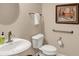 Neutral powder room with pedestal sink, tile floors, artwork, and modern fixtures at 1631 Caspian Dr, Carmel, IN 46032