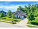 Attractive brick home with well-manicured lawn, mature trees, and a long driveway to the garage at 1631 Caspian Dr, Carmel, IN 46032