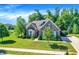 Beautiful brick home featuring well-manicured lawn, mature trees, and bright blue shutters at 1631 Caspian Dr, Carmel, IN 46032