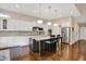 Well-lit kitchen features granite countertops, stainless appliances, white cabinetry, and hardwood floors at 1631 Caspian Dr, Carmel, IN 46032