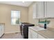 Well-organized laundry room featuring a sink, cabinets, countertops, and window view at 1631 Caspian Dr, Carmel, IN 46032
