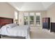 Bright main bedroom features tray ceiling, neutral walls, and a bed with wooden headboard beneath large windows at 1631 Caspian Dr, Carmel, IN 46032