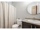 Bathroom with a shower/tub combo, a large round mirror, and a granite-style countertop at 17183 Petersfield Ln, Westfield, IN 46074