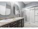 Well-lit bathroom with a double sink vanity, granite countertops, and a glass-enclosed shower at 17183 Petersfield Ln, Westfield, IN 46074