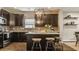 Stylish kitchen featuring dark cabinetry, granite countertops, stainless steel appliances, and an island with barstool seating at 17183 Petersfield Ln, Westfield, IN 46074