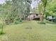 Expansive backyard featuring a house and deck surrounded by lush greenery at 1908 W Northgate St, Indianapolis, IN 46228