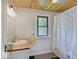 Bright bathroom with a wooden ceiling, white beadboard walls, and a shower at 1908 W Northgate St, Indianapolis, IN 46228