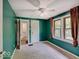 Green bedroom with carpet, ceiling fan, and natural light from two windows at 1908 W Northgate St, Indianapolis, IN 46228