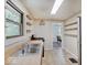 Functional kitchen area with double sink, floating shelves, and view to adjoining room at 1908 W Northgate St, Indianapolis, IN 46228