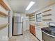 Functional kitchen with stainless steel refrigerator, gas range, and ample shelving at 1908 W Northgate St, Indianapolis, IN 46228