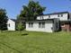 Spacious backyard with green grass, bordered by mature trees and privacy at 2211 Rosedale Dr, Indianapolis, IN 46227