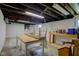 This unfinished basement has white painted walls, wooden support beams and natural light at 238 S 5Th Ave, Beech Grove, IN 46107