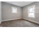 An empty bedroom is painted gray and features carpeted floors and two windows at 2954 N Washington Blvd, Indianapolis, IN 46205