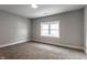 A bright bedroom with gray walls, neutral carpet, and a double hung window at 2954 N Washington Blvd, Indianapolis, IN 46205