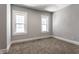 An empty bedroom is painted gray and features carpeted floors and two windows at 2954 N Washington Blvd, Indianapolis, IN 46205