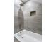 Bathroom shower with gray tiled walls, shower niche, and a rain style shower head at 2954 N Washington Blvd, Indianapolis, IN 46205