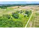 An aerial view of the property nestled among fields and trees, with several outbuildings and parking spaces at 3001 W 226Th St, Sheridan, IN 46069