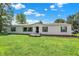 A charming single-story home with green shutters, a small porch, and a well-manicured lawn under a bright, cloud-filled sky at 3001 W 226Th St, Sheridan, IN 46069