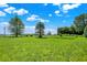 Vast green lawn with scattered trees under a bright sky, offering a serene and expansive outdoor space at 3001 W 226Th St, Sheridan, IN 46069