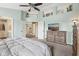 A bright bedroom is shown with a ceiling fan, dresser, and ample space at 301 Cobblesprings Ct, Avon, IN 46123