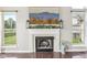 Cozy fireplace with mantle, flanked by windows providing ample natural light and green outdoor views at 301 Cobblesprings Ct, Avon, IN 46123