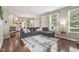 Open living room featuring hardwood floors, large windows, and a staircase in the background at 301 Cobblesprings Ct, Avon, IN 46123