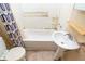Bathroom with pedestal sink, tub with shower curtain, and toilet at 320 N Colorado Ave, Indianapolis, IN 46201