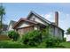 Exterior view of a home featuring a stucco facade, brick chimney, and lattice details at 320 N Colorado Ave, Indianapolis, IN 46201