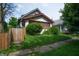 Charming home featuring a stucco exterior, quaint landscaping, and a picket fence at 320 N Colorado Ave, Indianapolis, IN 46201
